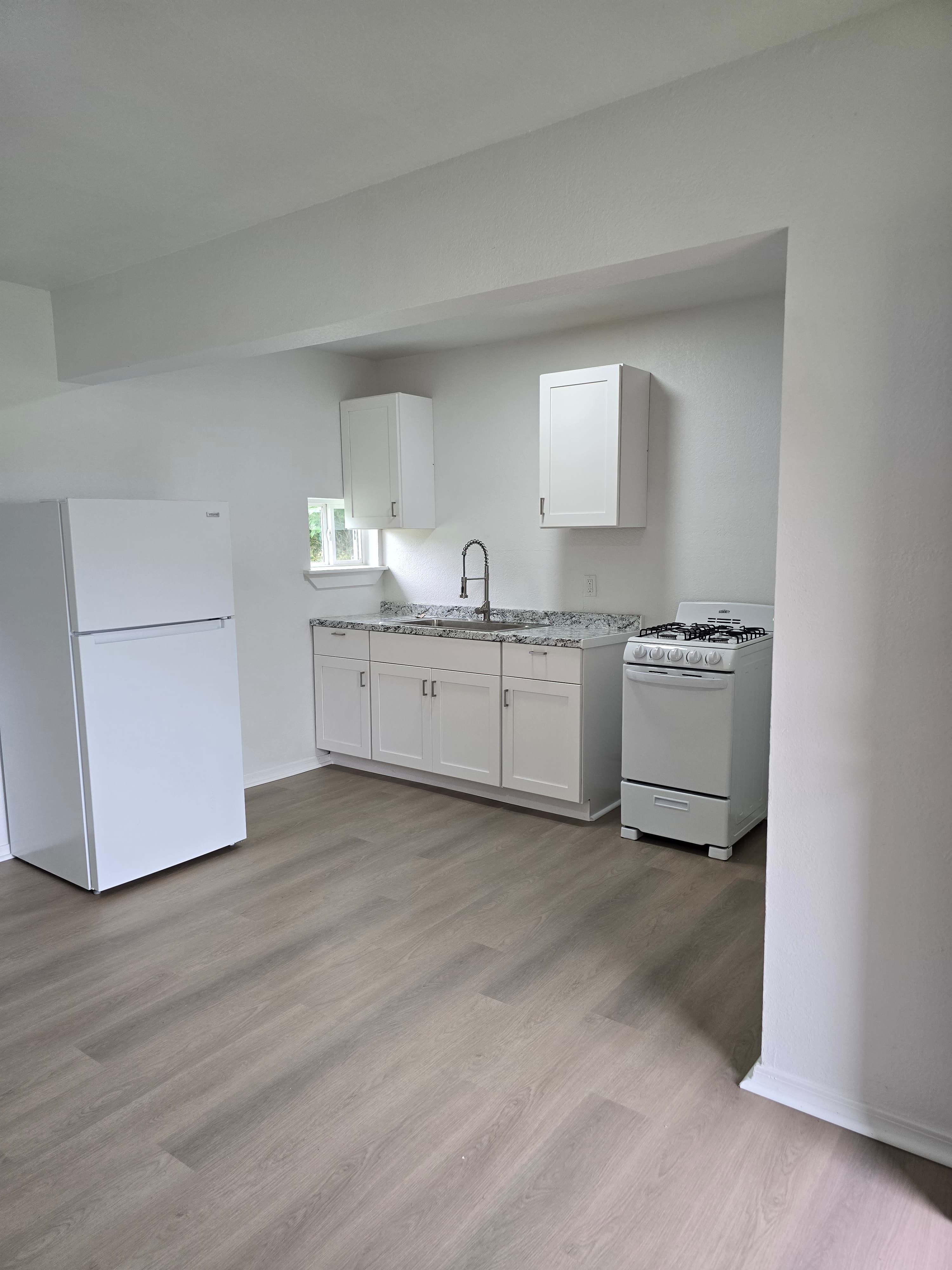Renovated One Bedroom Deluxe kitchen with white cabinets and new appliances